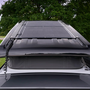 Monocrystalline solar panel installed on VW camper pop-top roof in outdoor setting