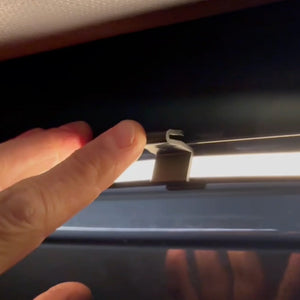Hand installing LED strip clip for awning lighting in VW California campervan