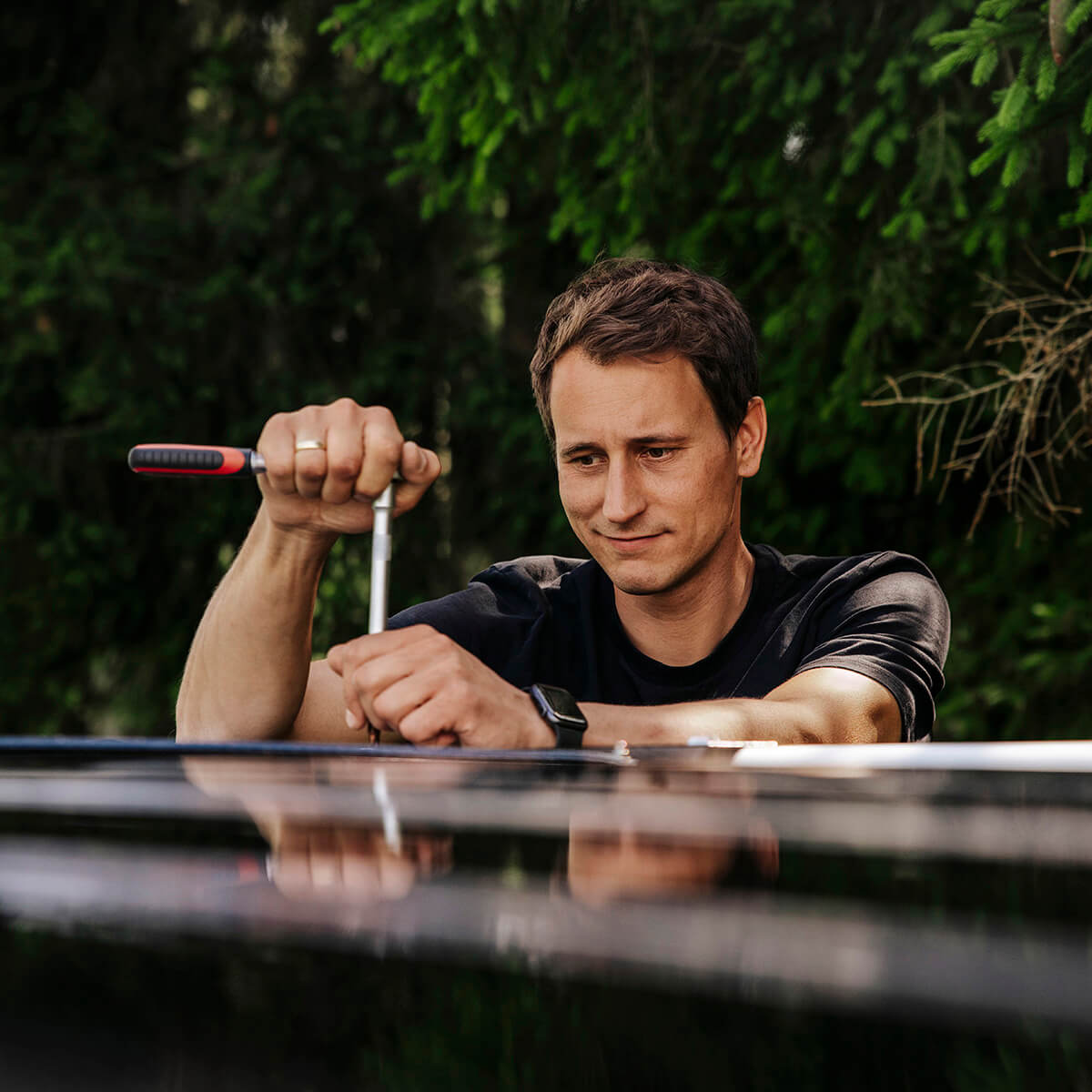 Selbsteinbau des CALIFAKTUR AutarkiepaketPRO im VW California: Person montiert Plug‑&‑Play‑Komponenten mit Werkzeug – ohne Bohren, rückrüstbar, mit Anleitung & Video‑Tutorials.