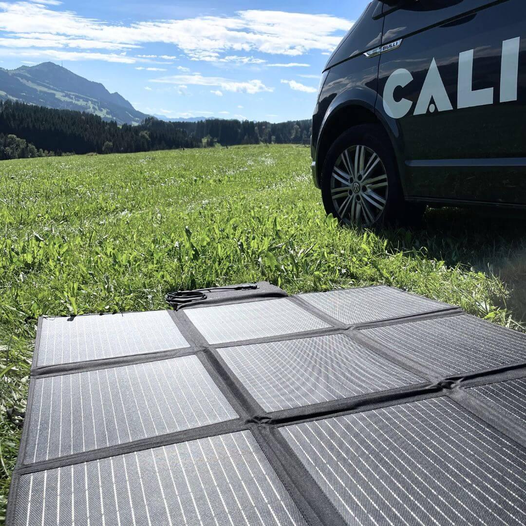 Solartasche für VW California auf Wiese, Gebirge im Hintergrund, sonniges Wetter