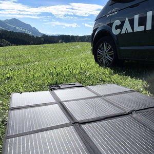 Solartasche für VW California auf Wiese, Gebirge im Hintergrund, sonniges Wetter